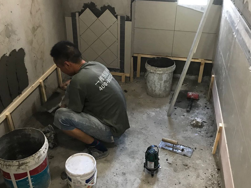 廁所瓷磚鋪貼裝修：首先應(yīng)除去基層表面的污垢，油漬，浮灰;除去基層上所有涂料層，膩?zhàn)訉?如果基層未能達(dá)到平整度要求，需對(duì)基層進(jìn)行預(yù)先的找平處理；鋪貼瓷磚前需事先找好垂直線，以此為基準(zhǔn)鋪貼的瓷磚高低均勻、垂直美觀;將調(diào)制好的漿料均勻地抹在瓷磚背面，要求漿料飽滿；將瓷磚平整地鋪貼在基層上，使用橡膠錘將瓷磚拍實(shí)鋪平。