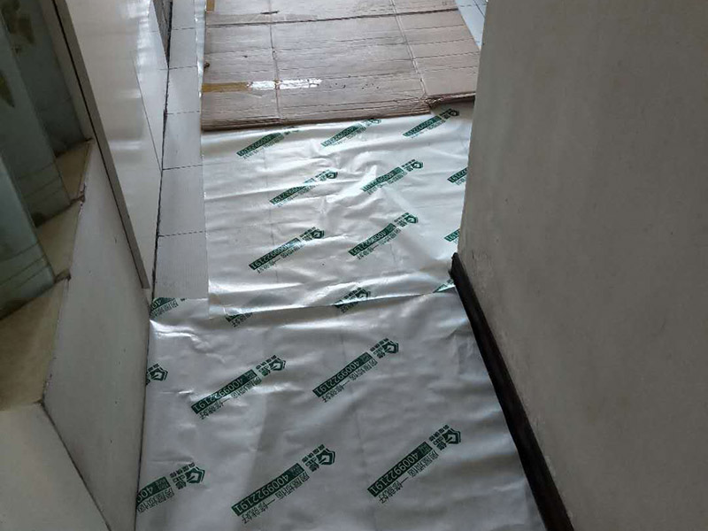 裝修地面保護：一、裝修地面保護膜鋪貼，一定是在地面（瓷磚、地板、地磚）貼好了才開始動手用裝修地面保護膜，要不然裝修地面保護膜是保護好你的地面了，但是地面（瓷磚、地板、地磚）松動了那就麻煩了，所以確認地面可以施工了這個步驟很重要！ 二、清理好地面（瓷磚、地板、地磚）表面的垃圾沙粒以及灰塵，這樣防止裝修地面保護膜在上面起到真正的保護做用（建議可以用拖把把地面清理干凈） 三、從客廳開始鋪設（建議先從面積大的地方來貼）然后逐漸到其他的地方，因為客廳是經(jīng)常走動的所以先貼好這樣不至于弄臟地面，這樣的裝修地面保護膜的保護效果更佳 四、鋪設裝修地面保護膜如果不是用專業(yè)的不基膠帶（用的是透明膠）那么就要很注意不要貼到地面上了，這樣會導致清理不干凈,那就會增加人工成本甚至刮花地面在清理的時候特別注意（木地板需要特別注意）；對于用于窗戶上的裝修保護膜，那對于窗戶的保護一定要用專業(yè)的膠帶來貼，這樣減少導致清理玻璃上的膠質(zhì)了