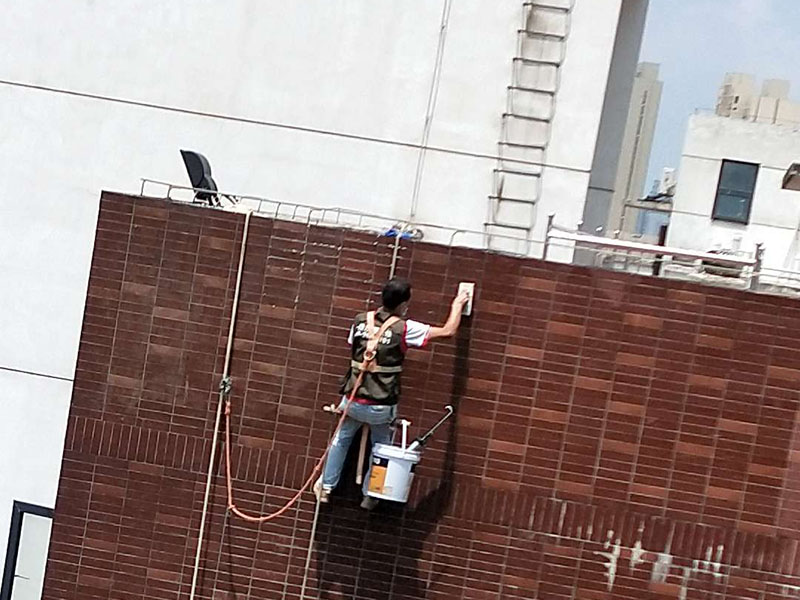 高空外墻防水：外墻面洞和較大裂縫防水密封前用噴水槍等工具將待治理的外墻面、伸縮縫、窗框等部位清理干凈，使施工的外墻面及縫、孔、洞部位達(dá)到無油、無塵土、無水泥松散顆粒等雜物。   待其干燥后，將孔、洞、縫用防水密封材料嵌填密實(shí)，并達(dá)到與原顏色一致，再用快速堵漏靈和透明防水膠膜進(jìn)行精心施工。整體條形瓷磚外墻面防水，采用高效環(huán)保型憎水進(jìn)行精心施工。該材料具有防水性能優(yōu)異、透氣性能良好、施工方便、使用安全、質(zhì)量可靠、耐久性好等特點(diǎn)。