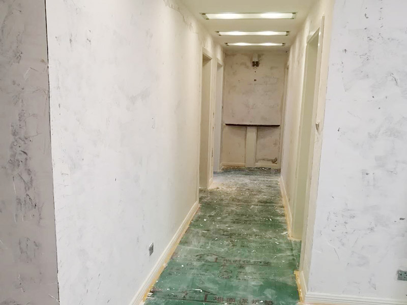 全屋墻面鏟除翻新：首先用水將墻面浸濕，這樣在鏟除墻面時比較省力，墻面必須要鏟到露出水泥砂漿面。然后是涂刷界面劑，一定要全部都刷到而且要均勻。墻面的裂縫通常都是用牛皮紙帶及白乳膠來貼住，但不能保證它能百分百不再開裂。 2、 如果墻面凹凸不平，那么就需要用石膏來找平，誤差最好不要超過0.5公分。非承重墻一般都是需要貼布的，所以最好選擇質地好的墻布和白乳膠，有條件的話可以使用網格布，對于防裂效果會更好。 3、 在挑選膩子時應該選顆粒細度高及質地較硬的，或是把白乳膠添加到膩子中提高膩子的硬度。打磨墻面要選用細砂紙，砂紙如果過粗會在墻面上留下很深的砂痕，就算是刷漆也沒辦法遮蓋住。墻面打磨之后要清掃一遍，否則粉塵過多會影響到漆的附著力。 4、 墻面在刷底漆時，一定要把每個地方都刷到并且要均勻。刷底漆要使用質地好滾筒，以免影響到底漆涂刷的效果。在膩子打磨之后，墻面都會留下一些比較難看的坑眼，特別是在刷漆后非常明顯，所以需要找補。在找補時一定要打磨平整，為了避免出現色差坑眼在底漆里多加一點水再涂刷。