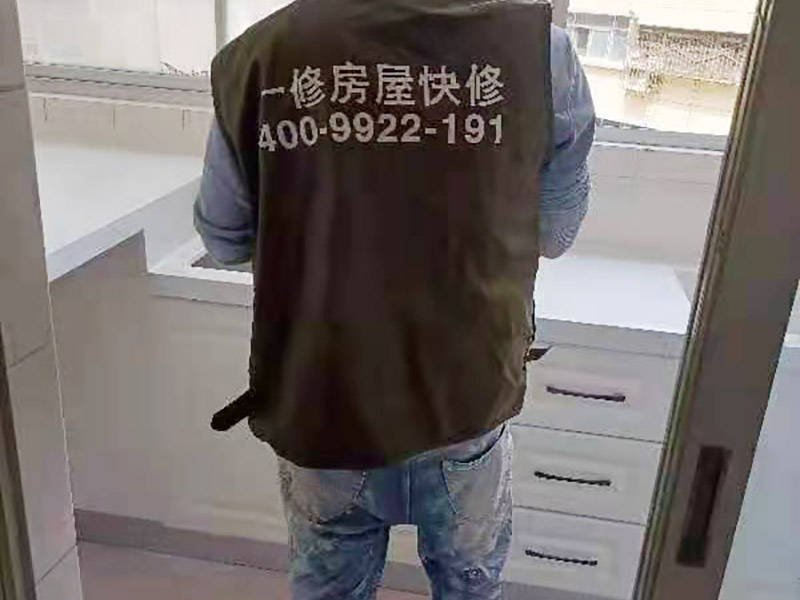 舊櫥柜更換安裝：櫥柜安裝一般先從地柜開(kāi)始。把櫥柜外包裝拆開(kāi)后。在櫥柜的邊緣貼上防火膜封邊。在下柜底部安裝上支腳，根據(jù)地面水平高度調(diào)整櫥柜。 櫥柜安裝需要找出基準(zhǔn)點(diǎn)，L型廚房從直角處向兩邊延伸，U型廚房則先將中間的一字型柜體放整齊后，再?gòu)膬蓚€(gè)直角處向兩邊站看，這樣可以避免出現(xiàn)縫隙。 櫥柜框架安裝牢固定位后，需要在櫥柜背面。一般安裝下水都會(huì)現(xiàn)場(chǎng)開(kāi)孔，工人會(huì)用專(zhuān)業(yè)的打孔器按照管道大小進(jìn)行打孔，打孔的直徑應(yīng)比管道大3-4毫米，并且打孔后要將開(kāi)孔部分用密封條封邊，防止邊緣滲水木材變形。把打好孔的背板根據(jù)櫥柜位置，依次封裝進(jìn)去。接下去就是安裝吊柜了。同下柜一樣，吊柜也需要根據(jù)需要現(xiàn)場(chǎng)打孔，比如脫排油煙機(jī)的排煙管的孔位。
